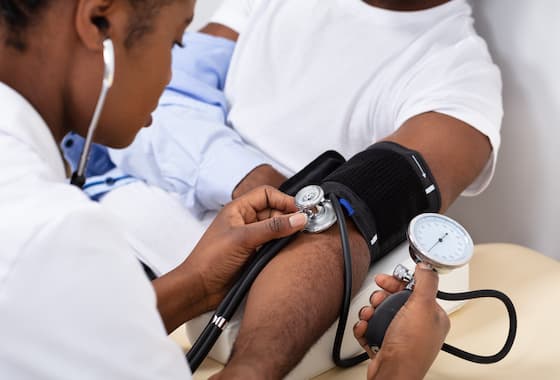 Doctor checking a patient's blood pressure at Amaris Medical Clinic